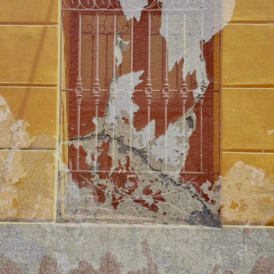 Red and ochre tile patterns layered over an old doorway.