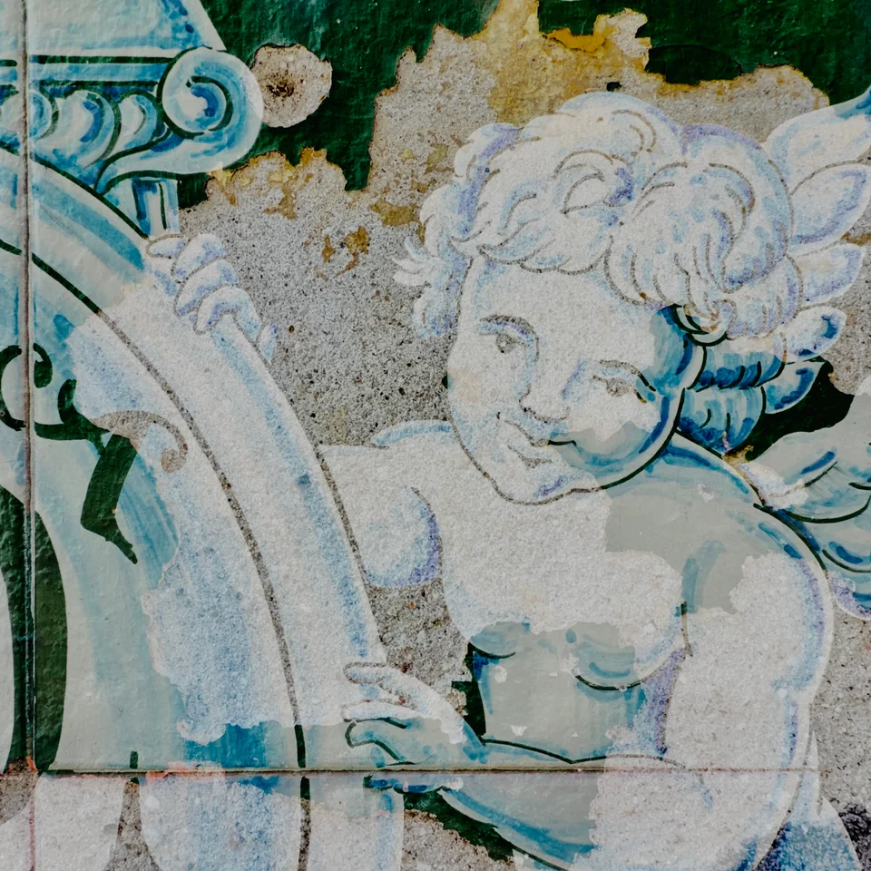 A sculpted cherub layered with blue and white decoration.