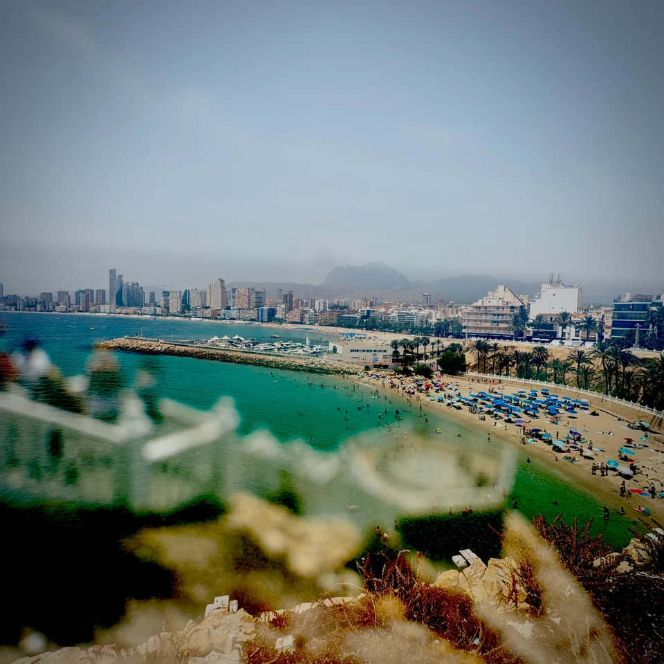 Turquoise water, a harbor, and distant mountains layered together.