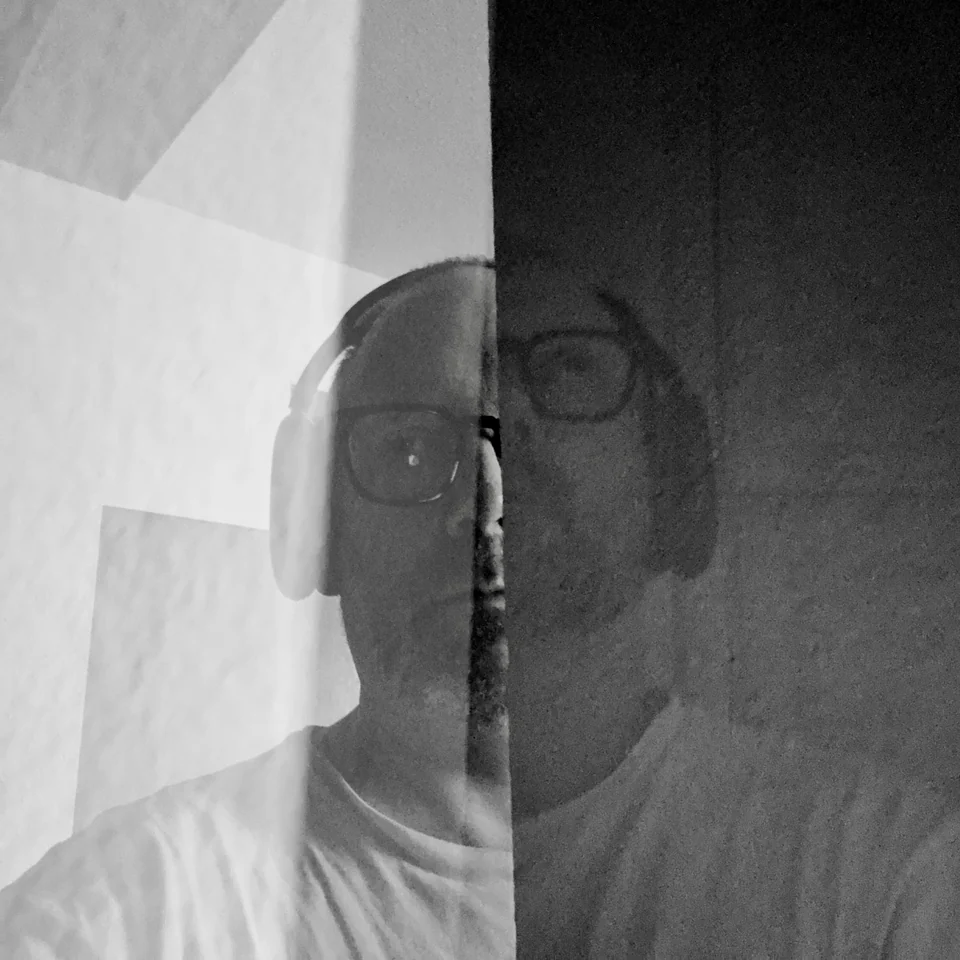 A black-and-white portrait layered with angular planes of light.