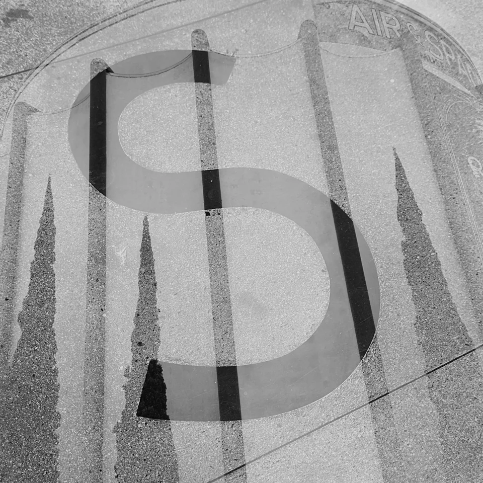 Overlapping letters and architectural details in black and white.